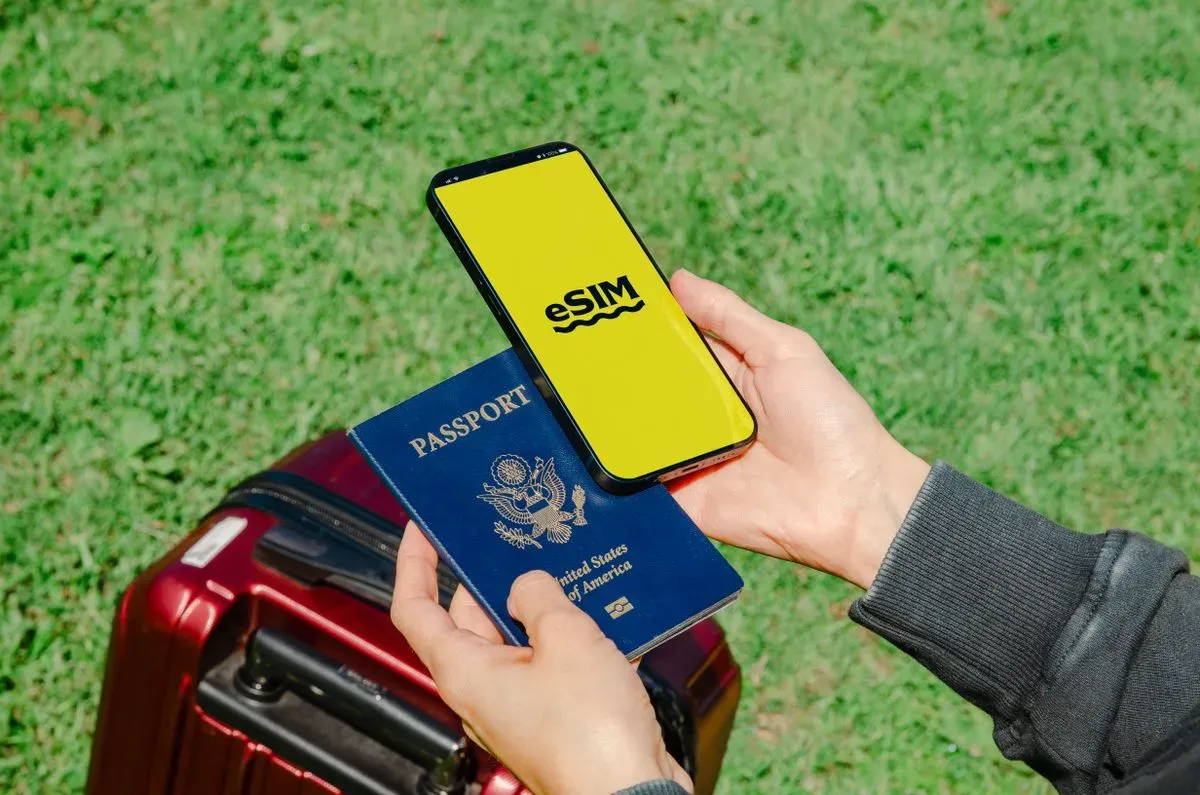 A traveler holding a passport and smartphone beside luggage