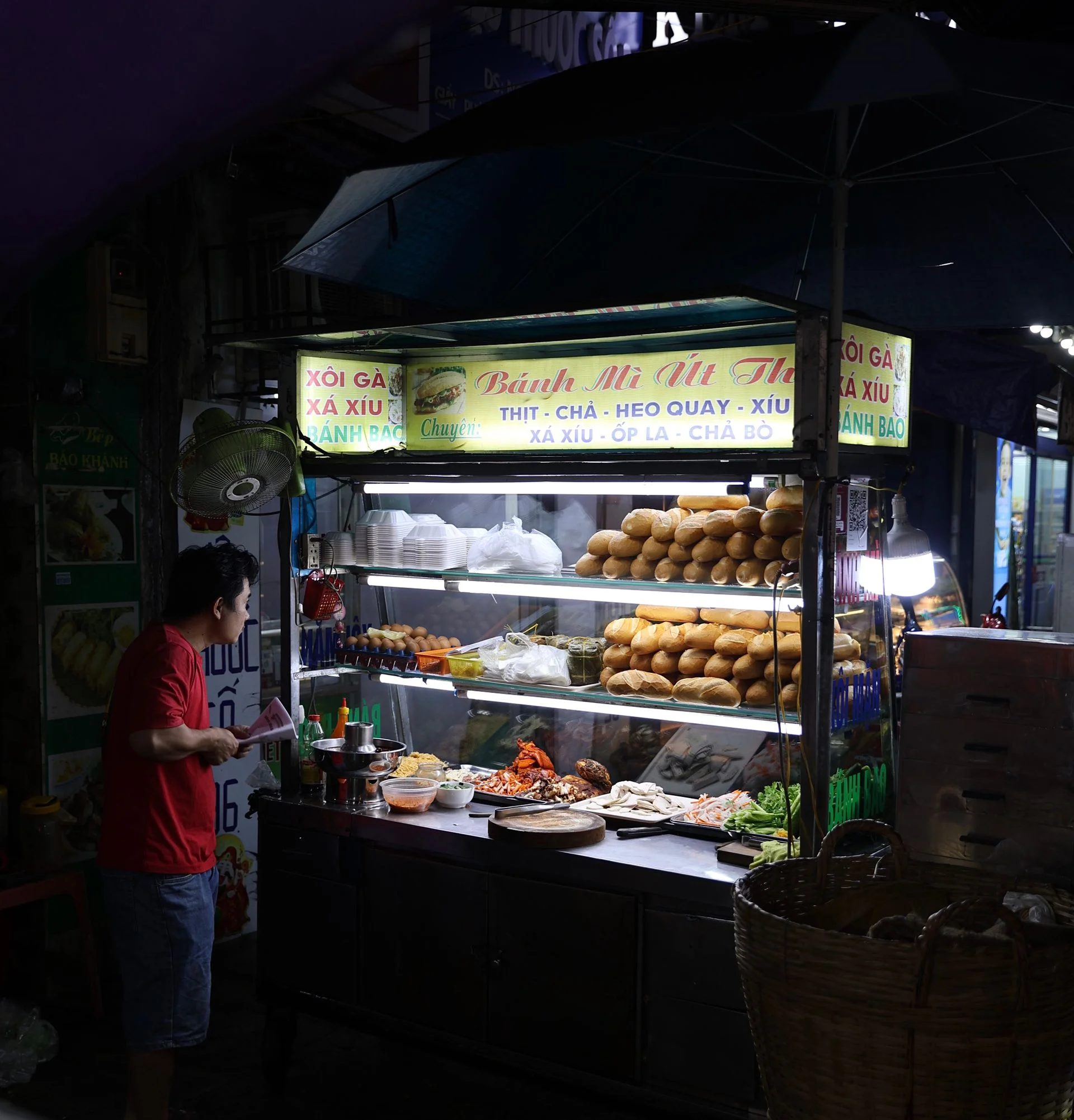 Make special requests before the sandwich is assembled. Vendor using tongs to assemble a banh mi at a sandwich counter